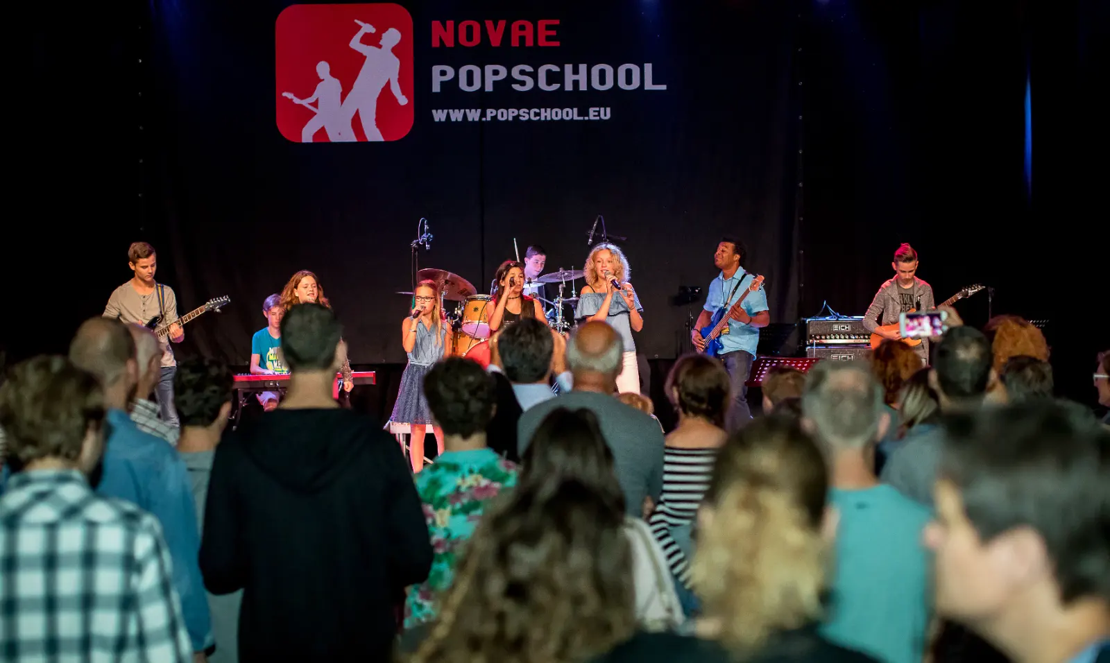 Publiek als silhouet voor een band op het podium